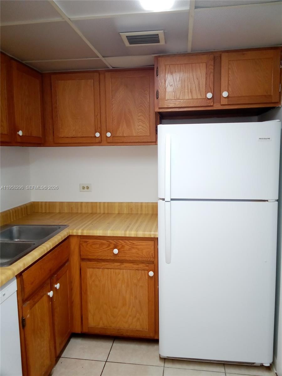 3720 Inverrary Drive, Unit 2S Lauderhill, FL 33319 - Photo 29 of 49 a kitchen with a refrigerator and cabinets
