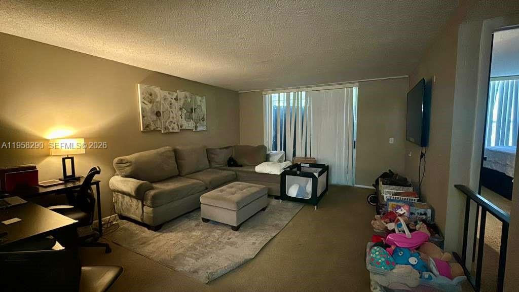 3720 Inverrary Drive, Unit 2S Lauderhill, FL 33319 - Photo 3 of 31 a living room with furniture and a flat screen tv