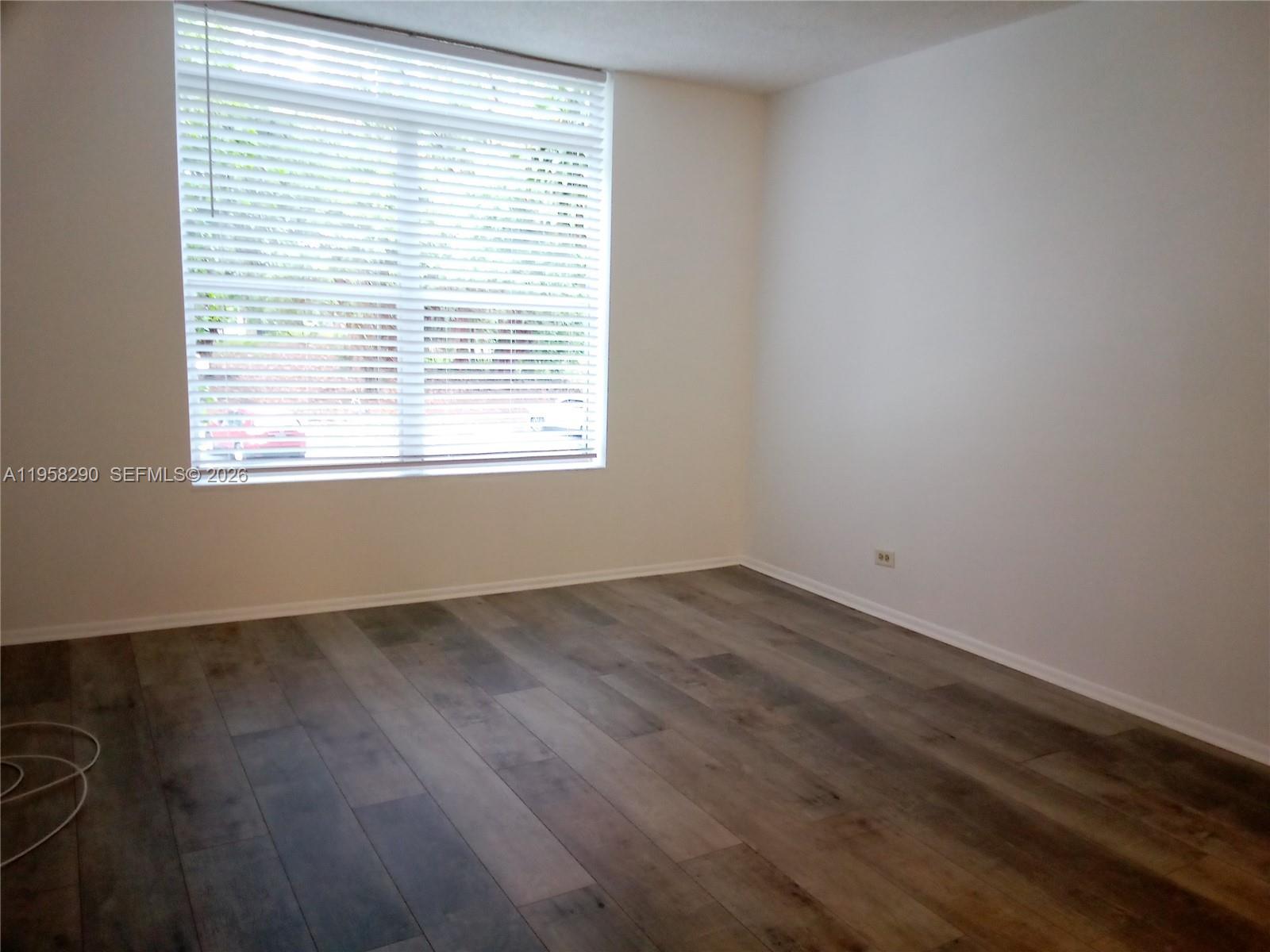 3720 Inverrary Drive, Unit 2S Lauderhill, FL 33319 - Photo 34 of 49 a view of an empty room with wooden floor and a window