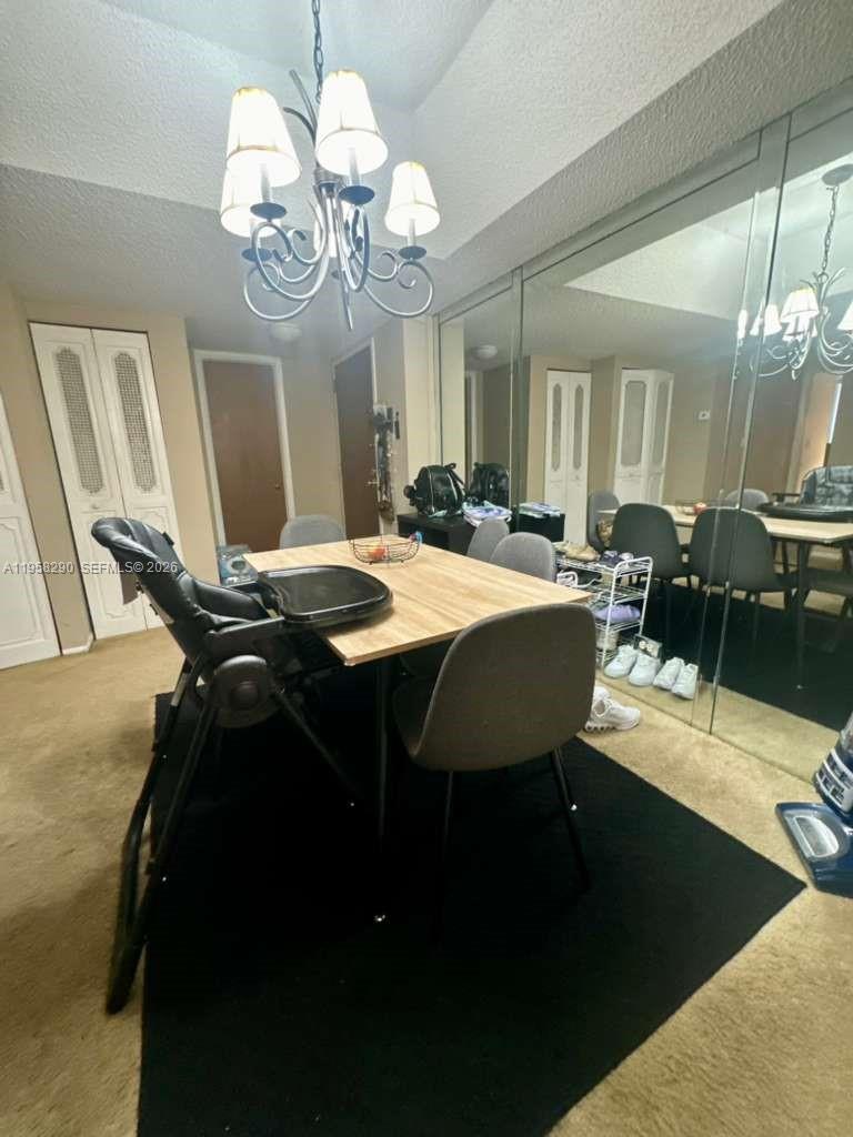 3720 Inverrary Drive, Unit 2S Lauderhill, FL 33319 - Photo 4 of 31 a dining room with wooden floor a chandelier a wooden table and chairs