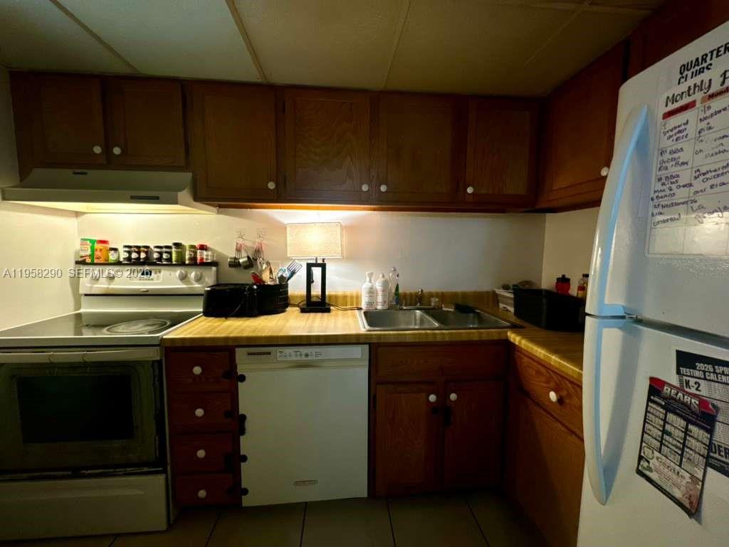 3720 Inverrary Drive, Unit 2S Lauderhill, FL 33319 - Photo 7 of 31 a kitchen with stainless steel appliances wooden cabinets and a stove top oven