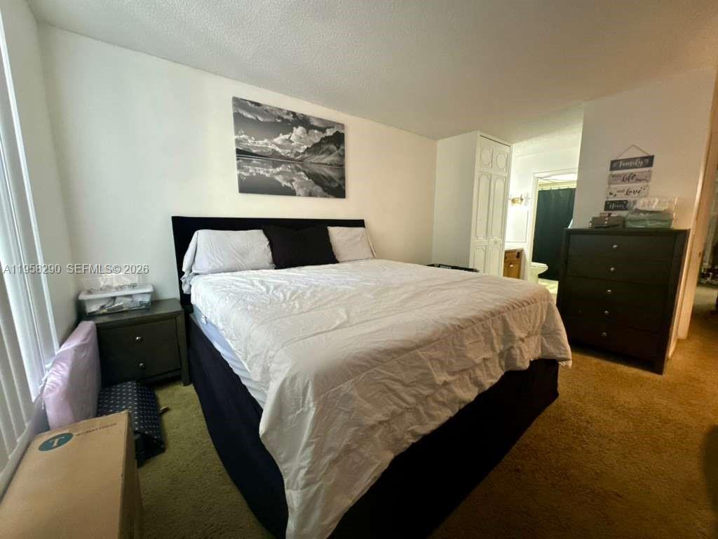 3720 Inverrary Drive, Unit 2S Lauderhill, FL 33319 - Photo 8 of 31 a bed sitting in a bedroom and a mirror
