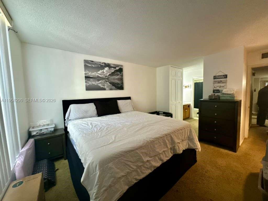 3720 Inverrary Drive, Unit 2S Lauderhill, FL 33319 - Photo 10 of 31 a bedroom with a bed and dresser