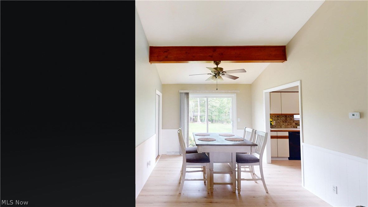 9260 Avery Road Broadview Heights, OH 44147 - Photo 10 of 43 Vaulted ceiling with an exposed wood beam, ceiling fan, wood-finish flooring, wainscoting, and a sliding glass door