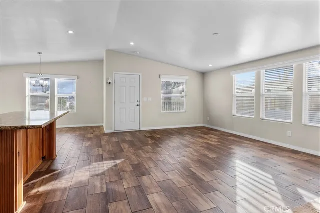 a view of an empty room with glass door and wooden floor