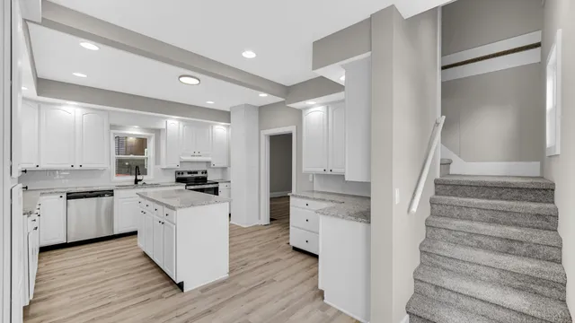 a kitchen with white cabinets and white appliances