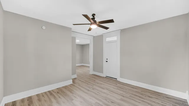 a view of empty room with wooden floor
