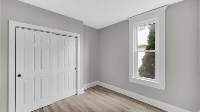 an empty room with windows and closet