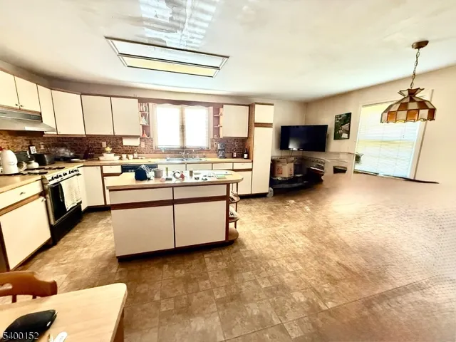 a kitchen with a stove a refrigerator and a stove top oven