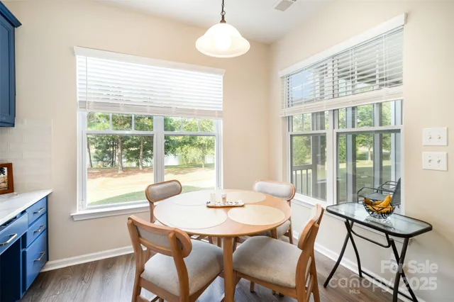 a dining room with furniture a chandelier and wooden floor