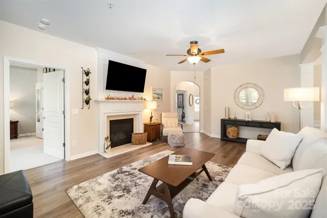 a living room with furniture a flat screen tv and a fireplace