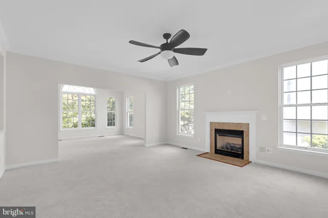 a view of empty room with a fireplace and windows