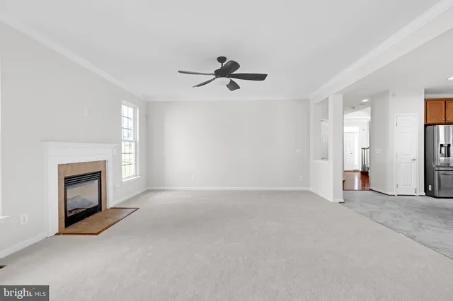 an empty room with fireplace and fan
