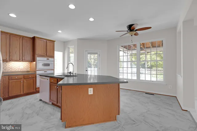 a kitchen with kitchen island granite countertop a sink stove and refrigerator