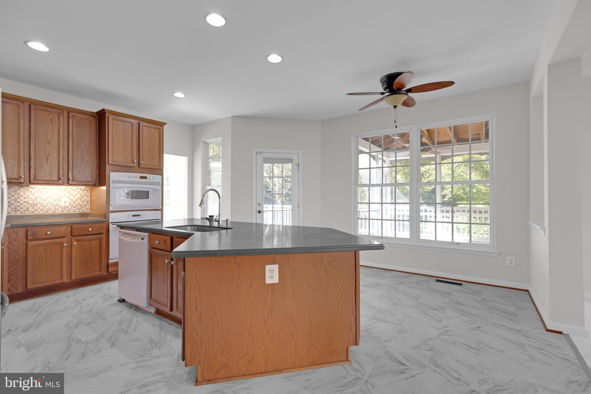 8566 Brickshire Lane Manassas, VA 20112 - Photo 14 of 59 a kitchen with kitchen island granite countertop a sink stove and refrigerator