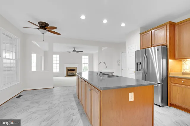 a kitchen with stainless steel appliances granite countertop a refrigerator a oven a sink with island and chairs