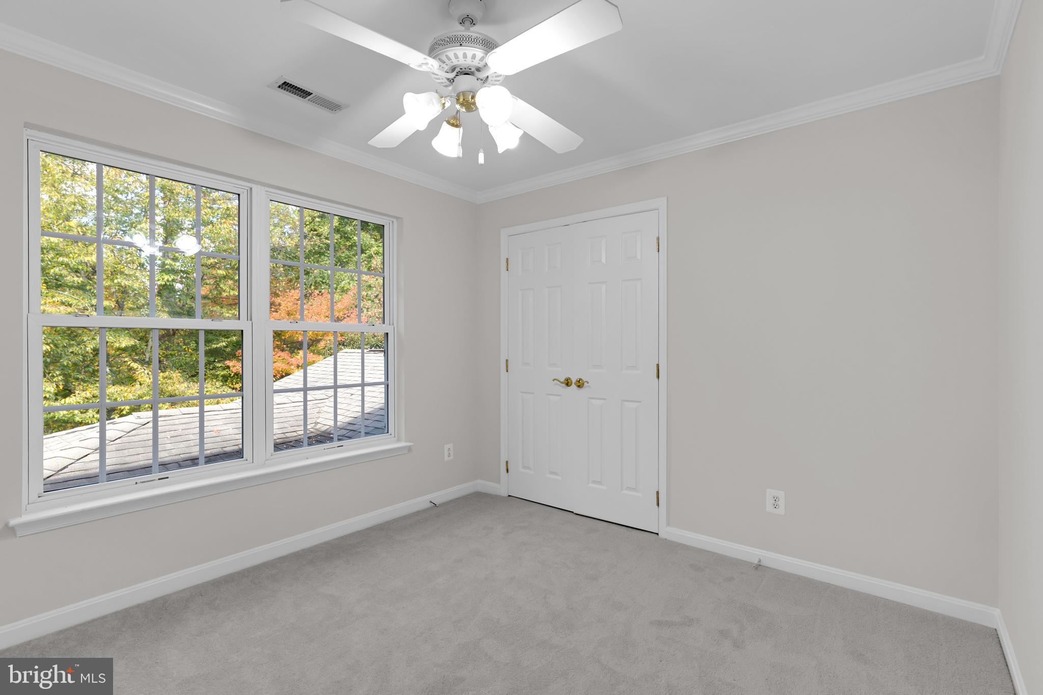 8566 Brickshire Lane Manassas, VA 20112 - Photo 34 of 59 an empty room with chandelier fan and windows