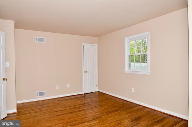 6902 Huntsman Boulevard Springfield, VA 22153 - Photo 13 of 27 a view of an empty room with wooden floor and a window