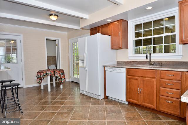 6902 Huntsman Boulevard Springfield, VA 22153 - Photo 25 of 27 a kitchen with a sink a table and chairs