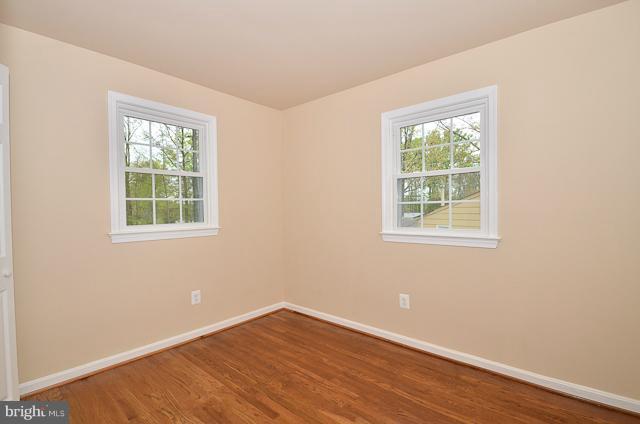 6902 Huntsman Boulevard Springfield, VA 22153 - Photo 7 of 27 an empty room with wooden floor and windows