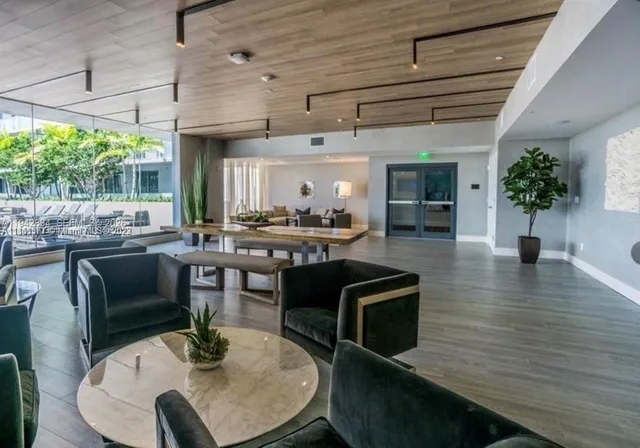 a dining room with furniture a floor to ceiling window and wooden floor