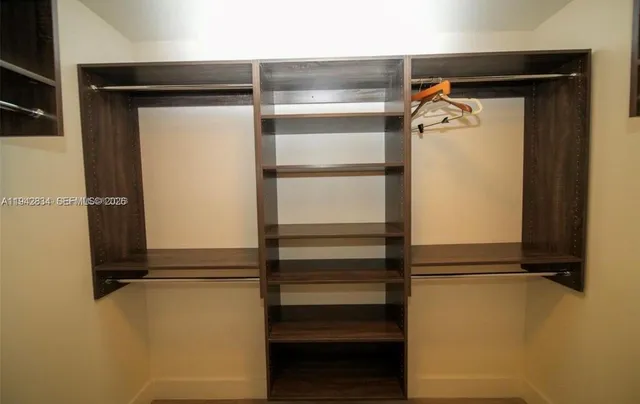 a view of walk in closet with empty racks