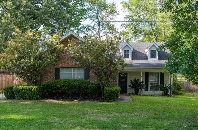 a front view of a house with a yard and trees