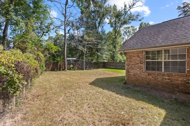 a view of a house with backyard and tree