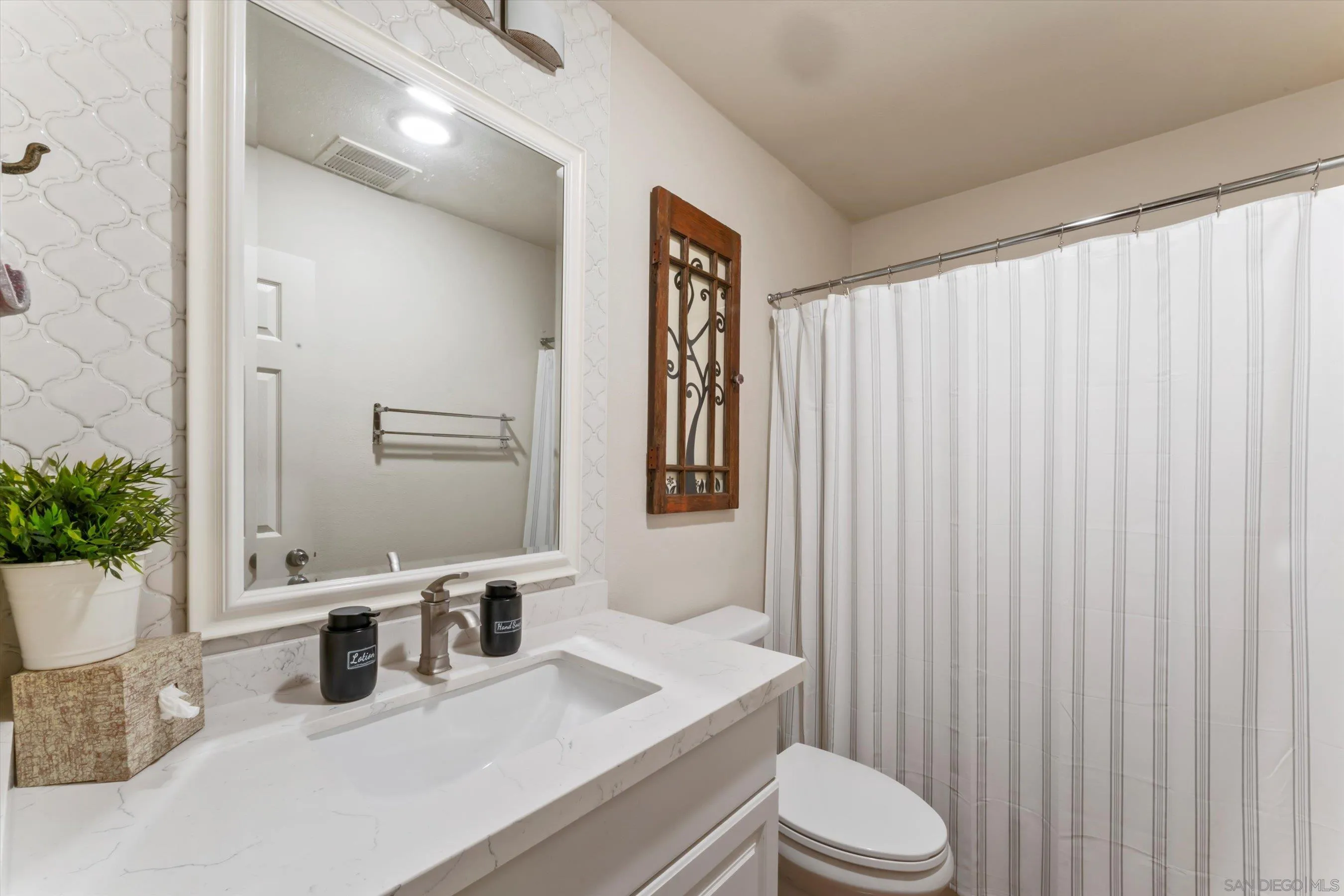 5483 Adobe Falls Road, Unit 7 San Diego, CA 92120 - Photo 11 of 20 a bathroom with a sink a toilet and mirror