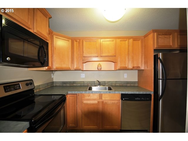 13320 Southwest Allen Boulevard, Unit 310 Beaverton, OR 97005 - Photo 8 of 18 a kitchen with granite countertop a stove a sink and a microwave