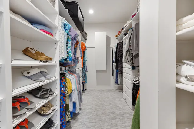 a view of walk in closet with clothes and shoes