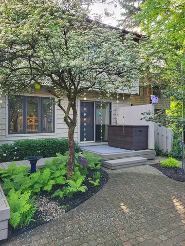 a front view of a house with a garden and plants