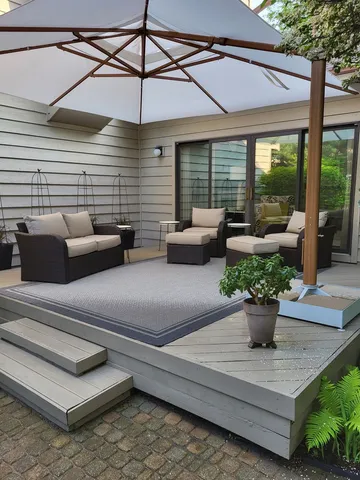 a view of a patio with couches chairs potted plants and floor to ceiling window