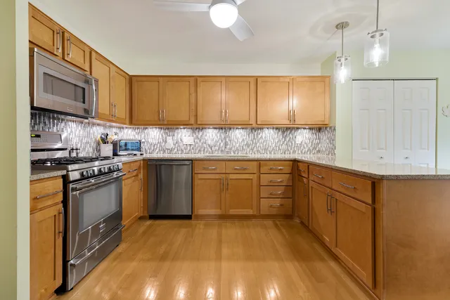 a kitchen with stainless steel appliances granite countertop a stove a sink and a refrigerator