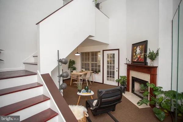 a living room with furniture a fireplace and a large window