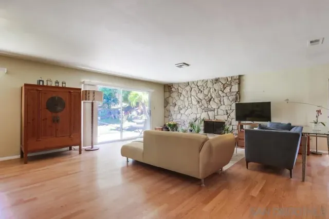 a living room with furniture a flat screen tv and a fireplace