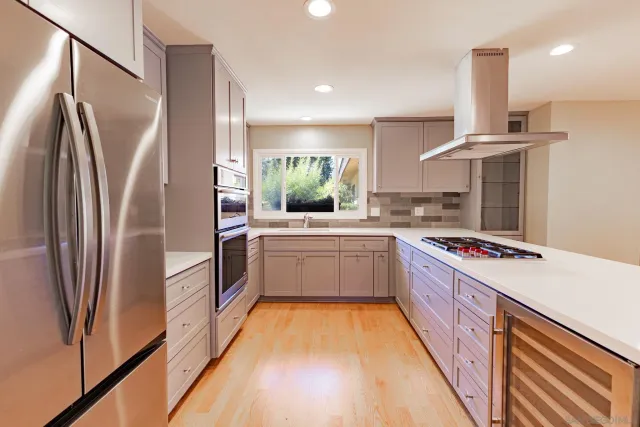 a kitchen with stainless steel appliances a sink and a refrigerator