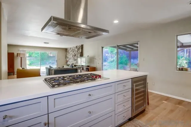 a kitchen with stainless steel appliances granite countertop a stove and a white cabinets