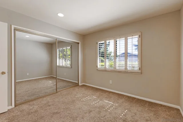 an empty room with windows and closet