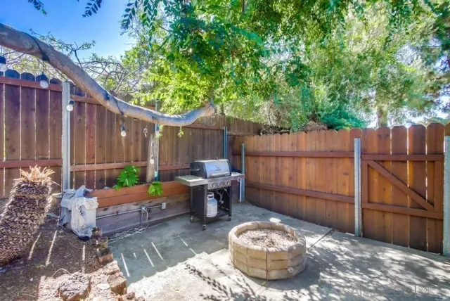 a view of a chair and table in backyard of the house