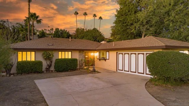 a view of a house with large windows and a yard
