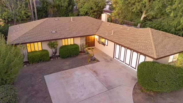 a view of a house with a yard and potted plants
