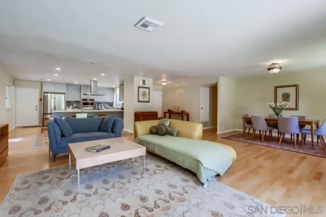 a living room with furniture and a dining table with kitchen view