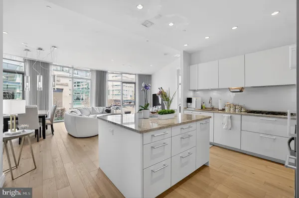a kitchen with white cabinets sink and stove