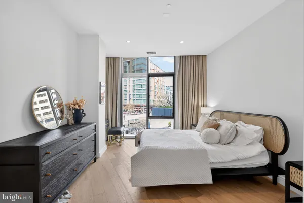 a spacious bedroom with a bed and a dresser