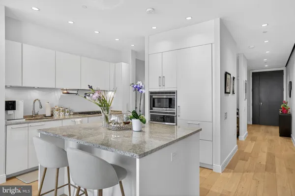 a kitchen with kitchen island granite countertop a sink and refrigerator