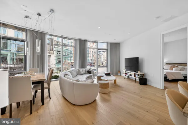 a living room with furniture a flat screen tv and a large window