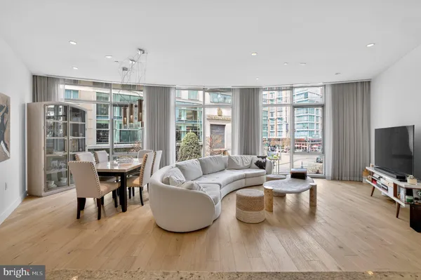a living room with furniture a large window and a flat screen tv