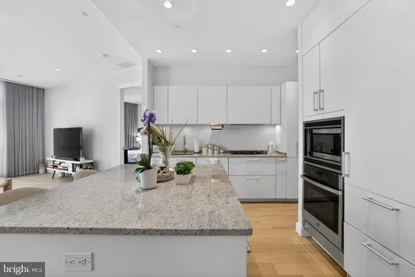 a kitchen with kitchen island granite countertop a stove sink and a granite counter tops