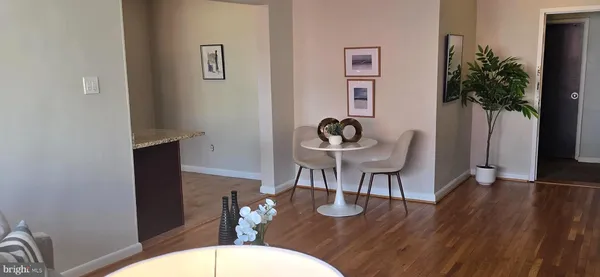 a dining room with wooden floor a glass table and chairs